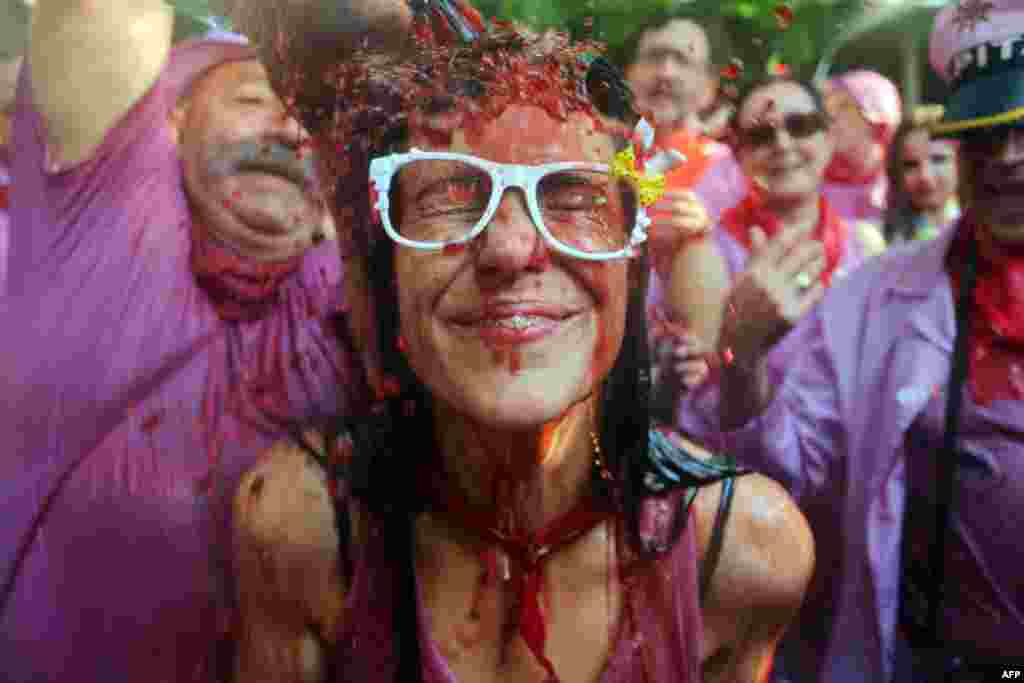 A man pours red wine on a girl&#39;s head during the &quot;Batalla del Vino&quot; (Battle of Wine) in Haro. Every year thousands of locals and tourists climb a mountain in the northern Spanish province of La Rioja to celebrate St. Peter&#39;s day and cover each other in red wine.