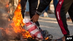 Les irakiens brulent un drapeau américain à Basra, le 30 décembre 2019.