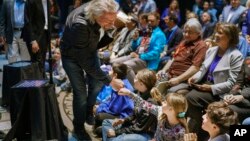 Virgin Galactic founder Richard Branson gives a fist bump to Sonia Thorp, 9, of Carlos Gilbert Elementary at the beginning of an event at the state Capitol, May 10, 2019, in Santa Fe, N.M.