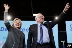 FILE - Democratic presidential candidate Hillary Clinton and Sen. Bernie Sanders, I-Vt., take the stage during a campaign stop in Durham, N.H., Sept. 28, 2016.