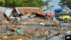 A man stands amid the damage caused by a tsunami in Palu, Central Sulawesi, Indonesia, Sept. 29, 2018. 