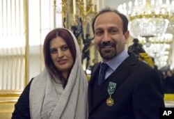 FILE - Iranian film director Asghar Farhadi and his wife, Parisa, pose after he was awarded the Officer of the Order of Arts and Letters medal, at the French Ministry of Culture, in Paris, France, Feb. 27, 2014.