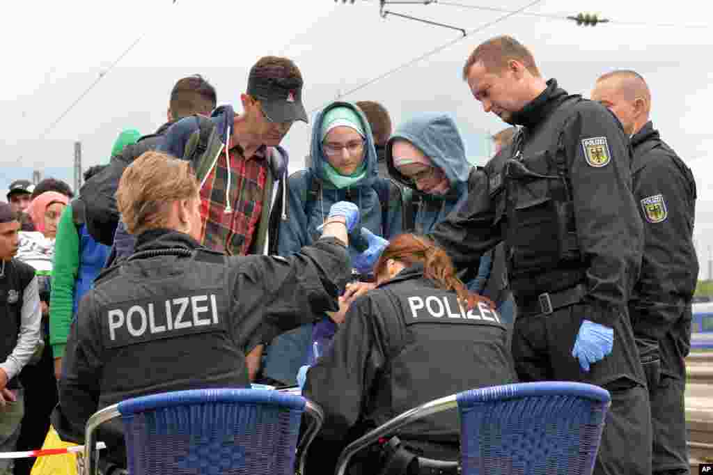 Policemen register refugees at the rail station in Freilassing, southern Germany before they take them away in busses.