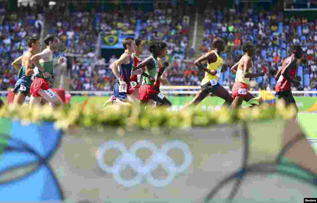 مردوں کی دوڑ کے مقابلے میں کھلاڑی ایک دوسرے پر سبقت لے جانے کی کوشش کر رہے ہیں۔