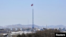 A giant North Korean flag flutters on the top of a tower in the propaganda village of Gijeongdong, North Korea, seen from South Korea, near the border village of Panmunjom, Feb. 15, 2013.