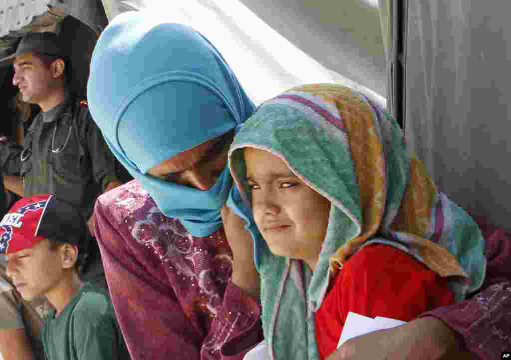 Syrian refugees wait outside a clinic at Zaatari Syrian refugee camp, in Mafraq, Jordan, Aug. 16, 2012. 