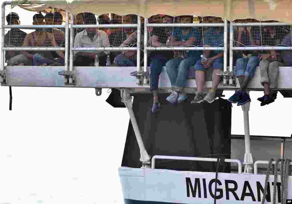 Para migran menunggu kapal berangkat dari kapal bantuan migran Phoenix, di pelabuhan Messina, Sicilia, Italia.