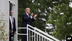 El presidente de EE.UU. Donald Trump aplaude a gente que lo saluda en su Club de Golf en Bedminster, Nueva Jersey, donde asistió al Abierto de Tenis Femenino, a su regreso de una visita a Francia. Julio 14 de 2017.