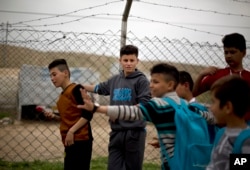 Ahmed Ameen Koro, 17, center, talks with other children after school in the Esyan Camp for internally displaced people in Dahuk, Iraq, April 13, 2017. Ahmed was among 200 Yazidi boys captured by Islamic State militants and sent to a two-month training camp in Tal Afar.