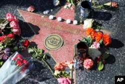 People start a memorial in Los Angeles for Carrie Fisher and Debbie Reynolds.