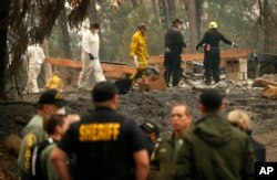 Investigators recover human remains at a home burned in the Camp Fire, Nov. 15, 2018, in Magalia, Calif. Many of the missing in the deadly Northern California wildfire are elderly residents in Magalia.
