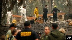 캘리포니아 마갈리아 지역 당국 관계자들이 15일 산불로 전소된 집터에서 유해를 수색하고 있다.
