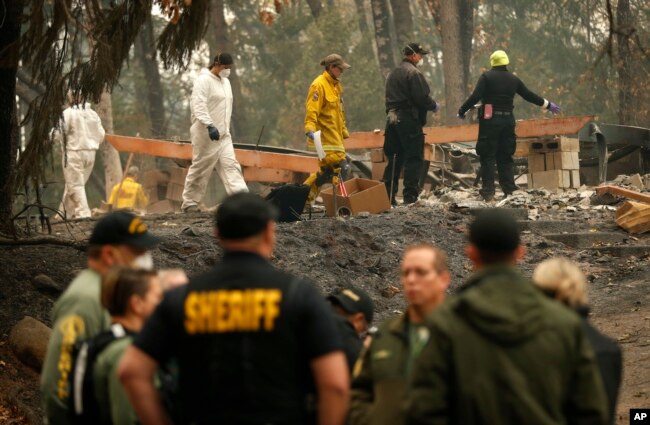 Investigators recover human remains at a home burned in the Camp Fire, Nov. 15, 2018, in Magalia, Calif.