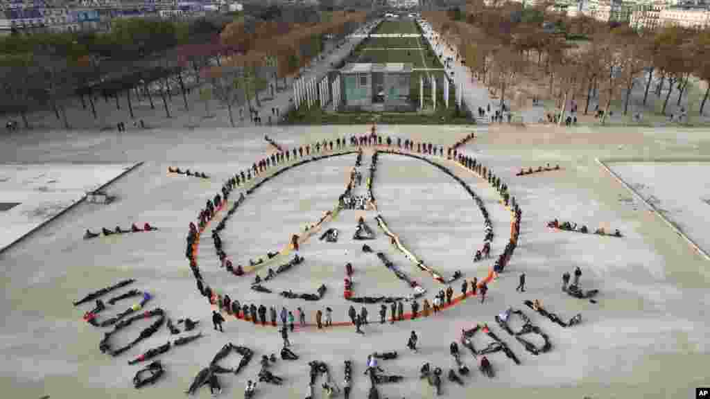 Des militants écologistes forment une chaîne humaine représentant le signe de la paix et mentionnant &quot;100% renouvelable&quot;, en marge de la COP21, non loin de la Tour Eiffel, à Paris, 6 décembre 2015.&nbsp;