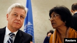 U.N. High Commissioner for Human Rights Navi Pillay (R) talks to Remigiusz Henczel, President of the Human Rights Council before the 22nd session of the Human Rights Council at the United Nations in Geneva Feb. 25, 2013.