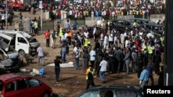 A crowd gathers at the scene of a bomb blast at a bus terminal in Nyayan, Abuja, Nigeria, April 14, 2014.