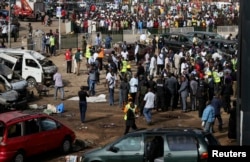 A crowd gathers at the scene of a bomb blast at a bus terminal in Nyayan, Abuja, Nigeria, April 14, 2014.
