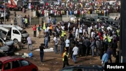 A crowd gathers at the scene of a bomb blast at a bus terminal in Nyayan, Abuja, Nigeria, April 14, 2014.