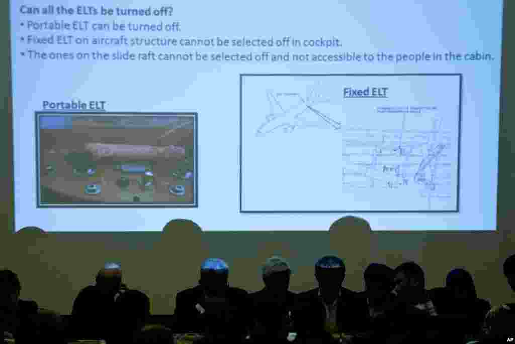 Malaysian officials attend a briefing for the relatives of Chinese passengers on flight MH370 as pictures of Emergency Locater Transmitters are shown at a hotel in Beijing, March 31, 2014.