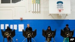 Voters cast their ballots at the Tuttle Park Recreation Center polling location, Nov. 6, 2018, in Columbus, Ohio. Across the country, voters headed to the polls Tuesday in one of the most high-profile midterm elections in years. 