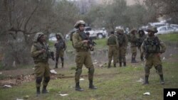 Israeli soldiers secure the scene after Palestinian teenager, Qusay Abo al-Rub, was shot and killed when he tried to stab a soldier in the village of Beita, south of the West Bank city of Nablus, Feb. 21, 2016. 
