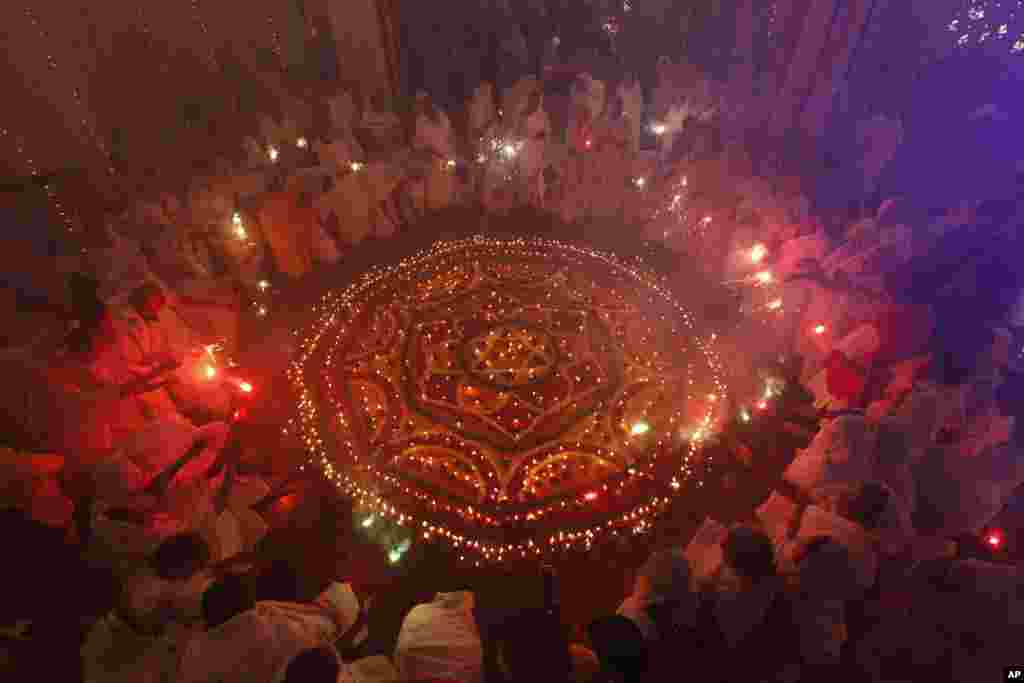 Indian widows light fireworks as they celebrate Diwali or the festival of lights at an Ashram in Vrindavan, India, Nov. 2, 2013. 