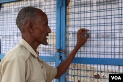 Somali man in Kakuma refugee camp checks the board to see if his name is on the list for an interview with the International Organization for Migration (IOM) for potential resettlement to the U.S. in Kakuma, Kenya, Feb. 6, 2017. (J. Craig / VOA)