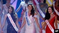 South African Rolene Strauss, (C), celebrates after being crowned Miss World 2014, during the finale of the competition at the ExCel Center in London Dec. 14 2014. She is flanked by Edina Kulcsar from Hungary and Elizabeth Safrit of the United States.