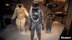 A Mercury era Space Suit (C) is displayed with a Soviet full pressure Strizh Rescue Space Suit (R) as part of the upcoming Space History Sale at Bonham's auction house in New York, April 4, 2014.