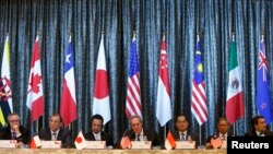 Perwakilan Perdagangan AS Michael Froman (tengah) diapit Menteri Ekonomi Jepang Akira Amari (tengah kiri) dan Menteri Perdagangan Singapore Lim Hng Kiang (tengah kanan), berada di atnara para Menteri Perdagangan Kanada, Peru, Malaysia dan Meksiko dalam konferensi pers yang diselengarakan di hari terakhir konferensi empat hari Konferensi Tingkat Menteri untuk Kerjasama Trans-Pasifik (TPP) di Singapura (25/2).