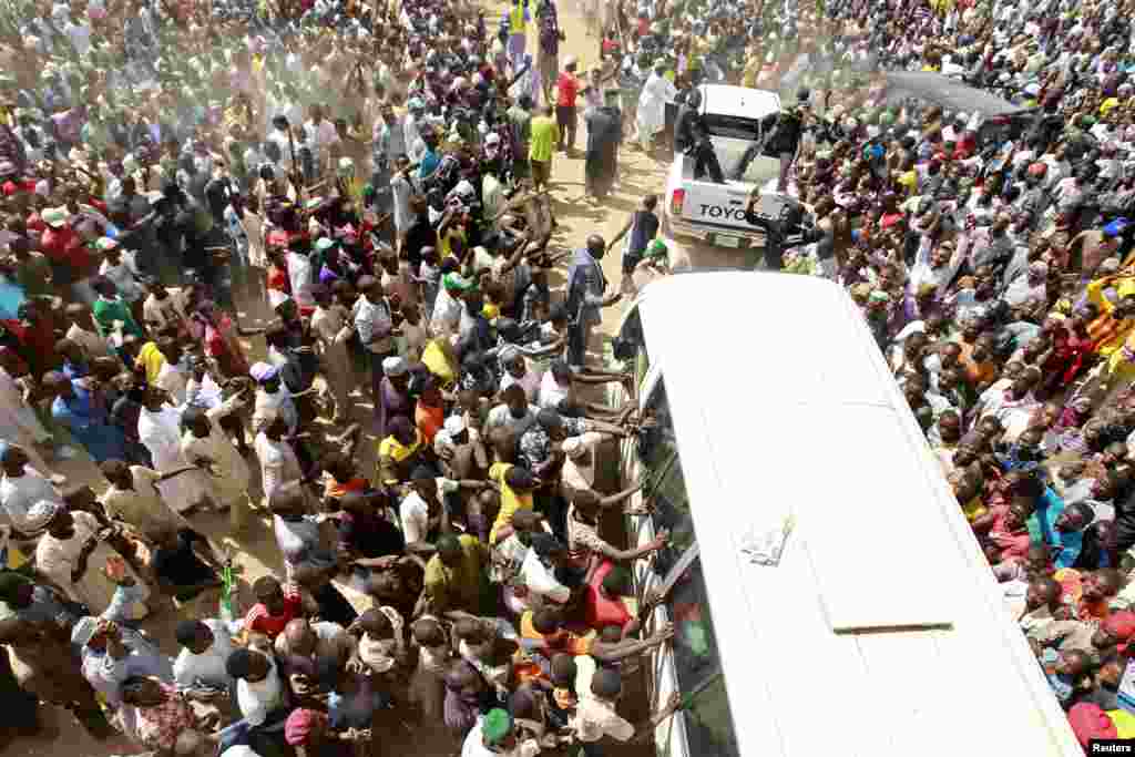 Supporters welcome Muhammadu Buhari (in vehicle), presidential candidate from the All Progressives Congress party, as he visits Gombe Emir Abubakar Shehu-Abubakarn at the emir&#39;s palace during an election rally in Gombe, Nigeria.