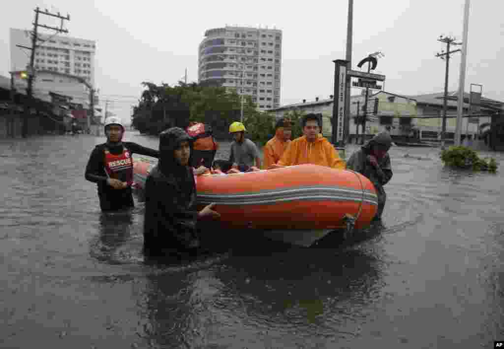 Tim penyelamat menggunakan perahu karet untuk mencari korban selamat di sepanjang wilayah Quezon City yang tergenang banjir (7/8). 