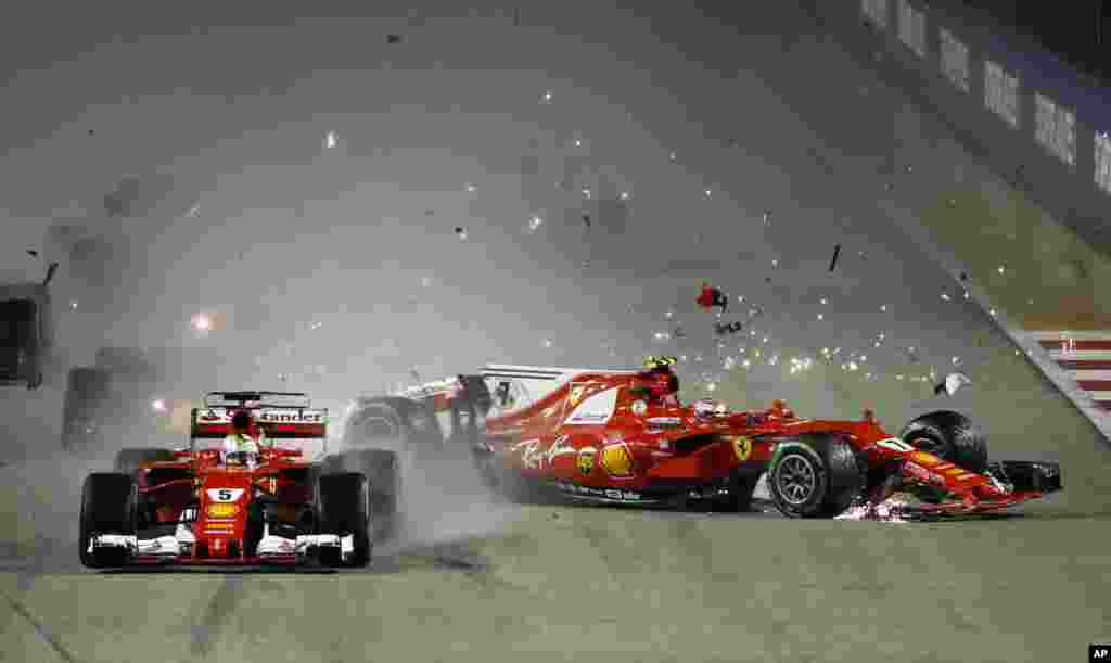 Ferrari driver Kimi Raikkonen, right, of Finland collides with teammate Sebastian Vettel of Germany at the start of the Singapore Formula One Grand Prix on the Marina Bay City Circuit Singapore.