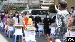 Authorities provide essential food to residents living in Psar Kandal I commune during the country's lockdown in Phnom Penh and Takhmau city, Cambodia, on April 26, 2021. (Kann Vicheika/VOA Khmer)