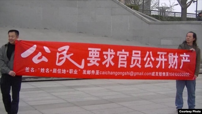 2014年丁家喜推特图片显示北京几位公民在闹市西单展示要求官员公开财产的横幅。