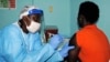 FILE - A health worker injects a woman with an Ebola vaccine during a trial in Monrovia, Feb. 2, 2015. 