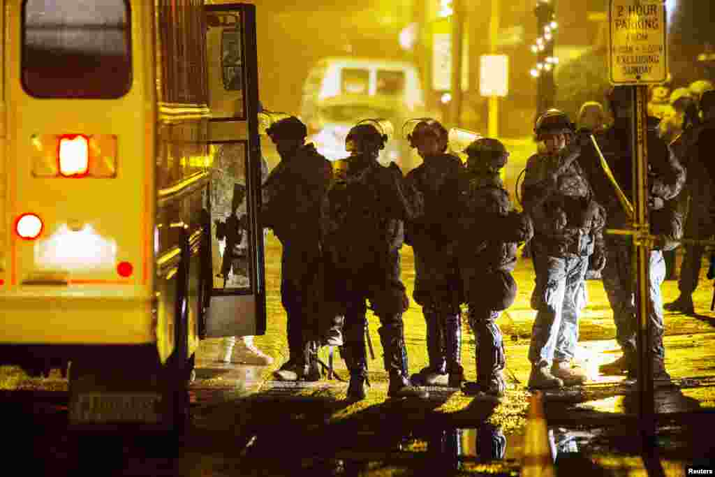 National Guard soldiers board a bus outside of the Ferguson City Hall during a third night of protests following the grand jury verdict in the Michael Brown shooting in Ferguson, Missouri, Nov. 26, 2014.