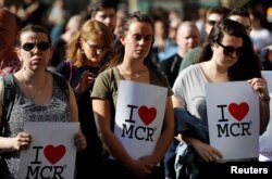 Women wait to take part in a vigil for the victims of an attack on concert goers at Manchester Arena, in central Manchester, Britain, May 23, 2017.