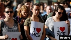 Women wait to take part in a vigil for the victims of an attack on concert goers at Manchester Arena, in central Manchester, Britain, May 23, 2017.