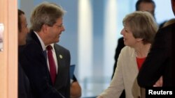 Italian Prime Minister Paolo Gentiloni, welcomes British Prime Minister Theresa May prior to a gathering of European leaders on the upcoming G-20 summit in the chancellery in Berlin, Germany, June 29, 2017.