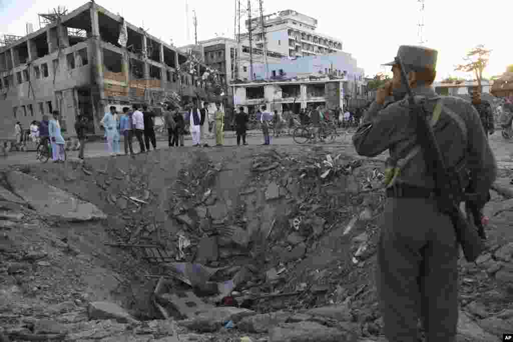 Security forces stand next to a crater created by massive explosion in front of the German Embassy in Kabul, Afghanistan, May 31, 2017. 