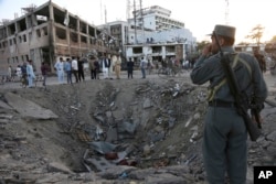 Security forces stand next to a crater created by massive explosion in front of the German Embassy in Kabul, Afghanistan, May 31, 2017.