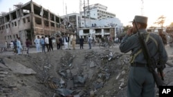 Security forces stand next to a crater created by massive explosion in front of the German Embassy in Kabul, Afghanistan, May 31, 2017. 