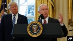 FILE - President Donald Trump listens as Attorney FILE - General Jeff Sessions speaks in the Oval Office of the White House in Washington, Feb. 9, 2017, after Vice President Mike Pence administered the oath of office to Sessions. 