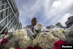 Một người đàn ông đặt hoa tưởng niệm các nạn nhân thiệt mạng trong vụ nổ bom tại một buổi lễ ở đền Erawan.