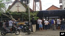 Onlookers gather outside of St. Lidwina Church following an attack in Sleman, Yogyakarta province, Indonesia, Feb. 11, 2018. Police shot a sword-wielding man who attack the church during a mass, injuring a number of people.
