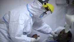 Dr. Matias Norte comforts a patient infected with COVID-19 at a hospital in Buenos Aires, Argentina, Saturday, July 18, 2020. (AP Photo/Natacha Pisarenko)