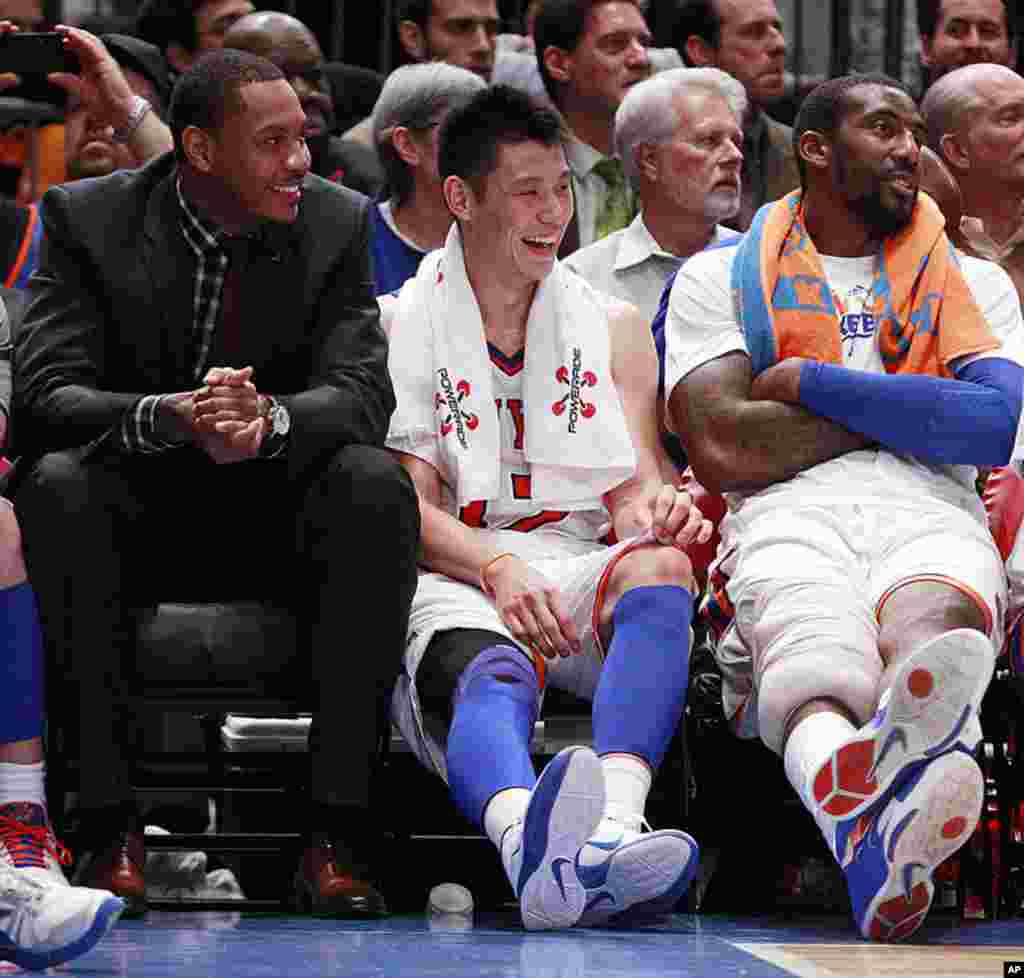 New York Knicks' Jeremy Lin, center, talks with teammates Carmelo Anthony, left, and Amare Stoudemire, right, during an NBA basketball game against the Sacramento Kings, February. 15, 2012, in New York. The Knicks won the game 100-85. (AP)