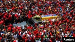 The coffin of Venezuela's late President Hugo Chavez is driven through the streets of Caracas after leaving the military hospital where he died of cancer in Caracas, March 6, 2013. 