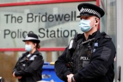 Polisi berjaga di luar kantor mereka pada pagi hari pasca demonstran bentrok dengan polisi saat aksi protes di Bristol, Inggris, 22 Maret 2021. REUTERS / Paul Childs